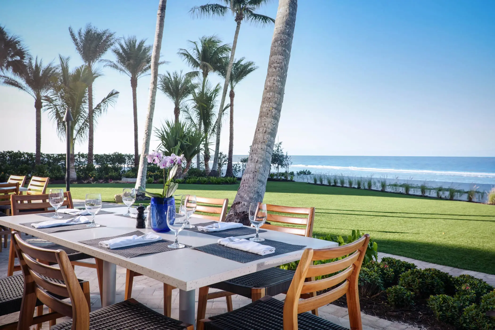A table on a patio with a view of the yard and beach area at LaPlaya