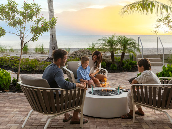 Family Roasting Marshmallows On The Beach